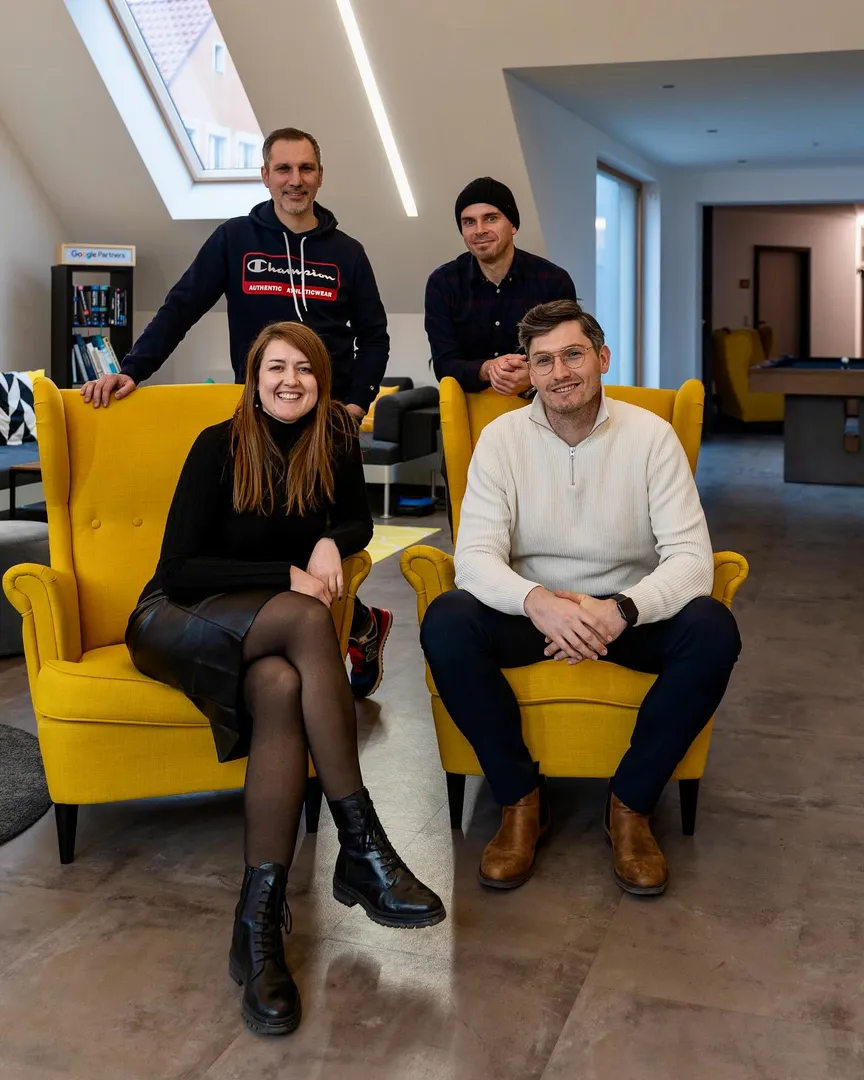Gruppenfoto in der Lounge der C3 marketing agentur: Anja Meixner und Alexander Schirmer sitzen vorne in gelben Sesseln, hinter ihnen stehen Thomas Franz und Christian Reisnecker. Das Bild zeigt das erweiterte Führungsteam in entspannter Atmosphäre.