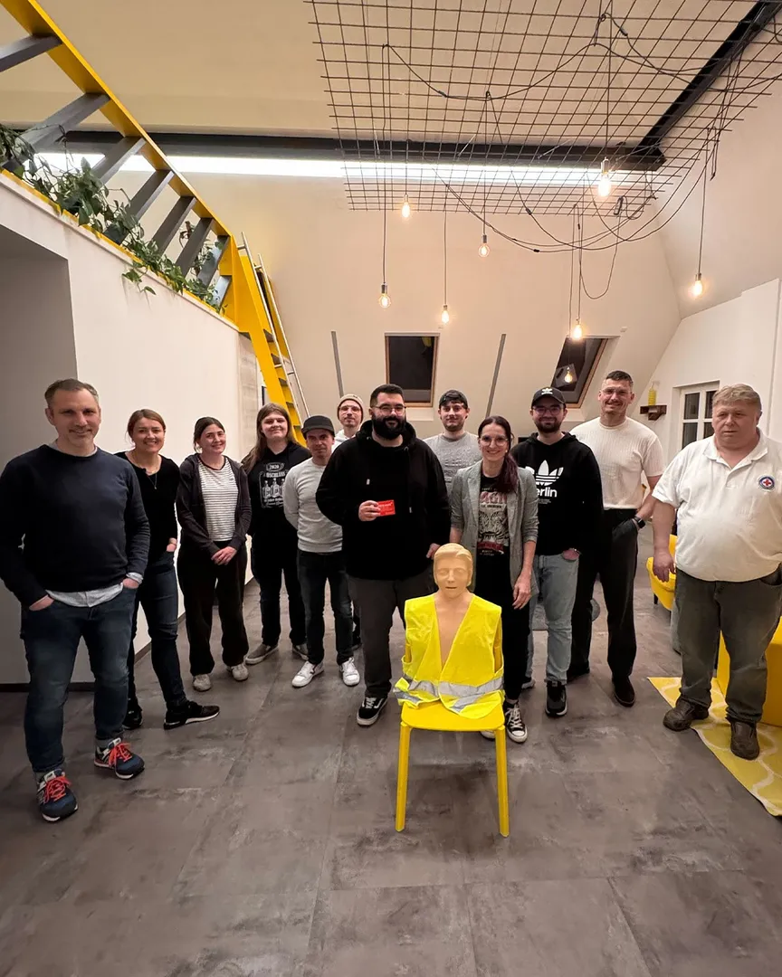 Das Team der C3 marketing agentur versammelt sich mit einem Erste-Hilfe-Dummy in der Mitte zu einem Gruppenfoto in den Agenturräumen. Alle Teilnehmenden haben erfolgreich am Erste-Hilfe-Kurs teilgenommen.