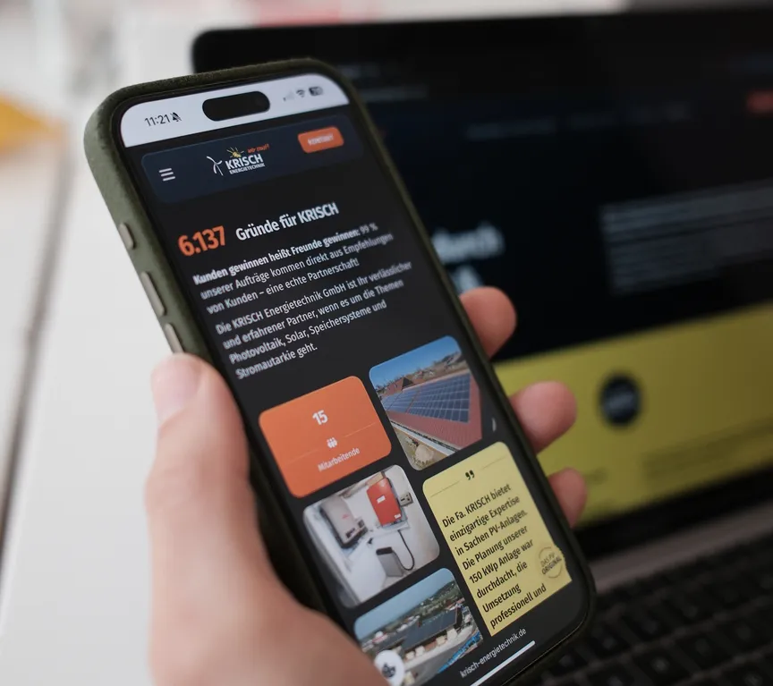 Smartphone mit responsiver Ansicht der Website der KRISCH Energietechnik GmbH, gehalten von einer Person